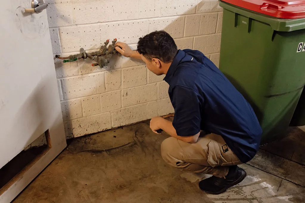 Anthony Capasso examining exposed external pipework