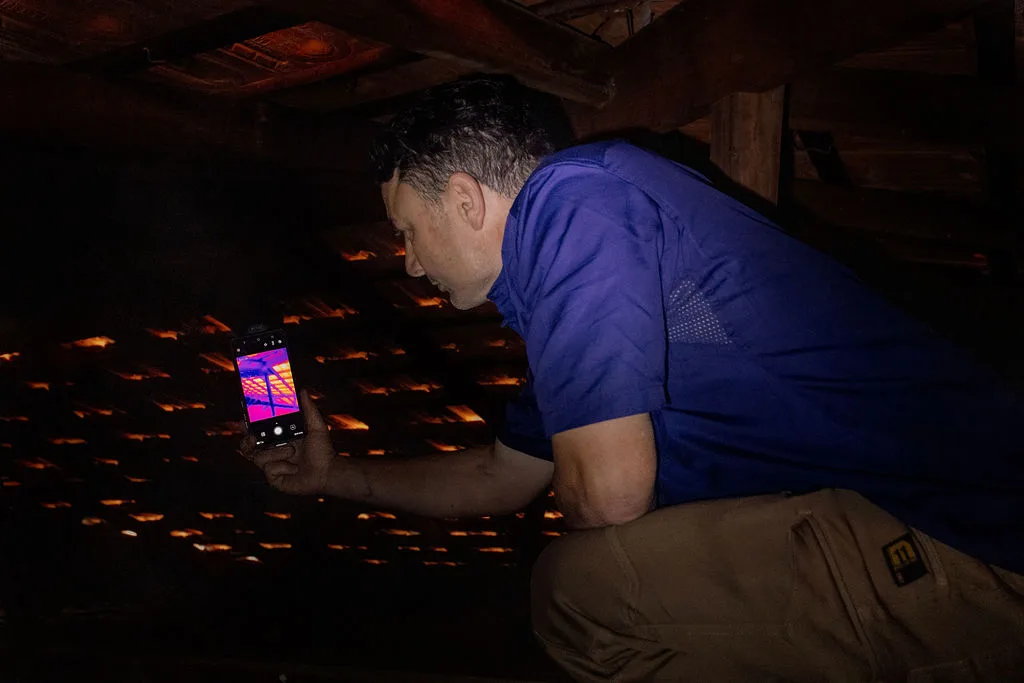 Anthony Capasso using a thermal camera inside a roof space